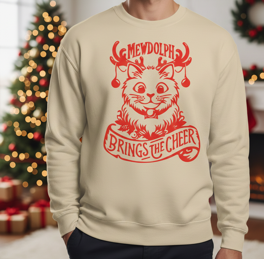 Beige sweatshirt with red Christmas-themed design featuring a cat and text, worn by a person in a festive setting.